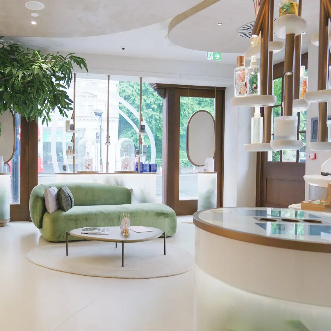 HVN Knightsbridge lounge by SheridanCX, green velvet sofa, indoor tree and product display alongside the front window
