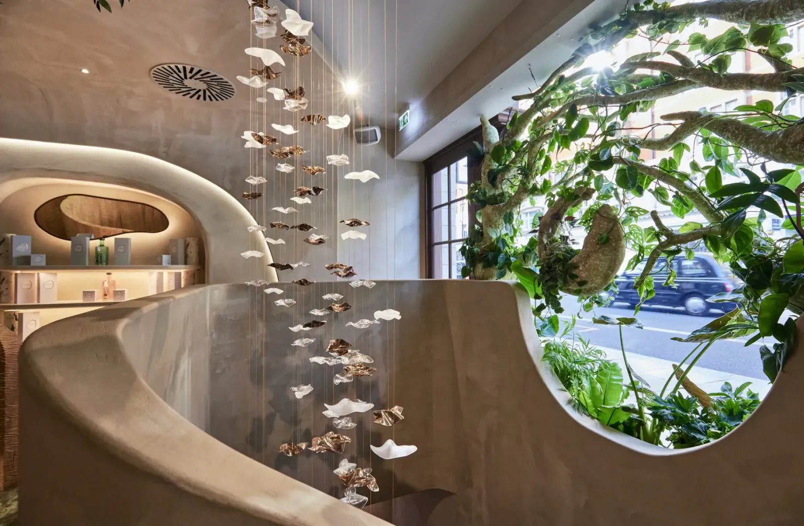 HVN Knightsbridge staircase by SheridanCX with a suspended glass and bronze leaf installation and an organic window aperture onto the street