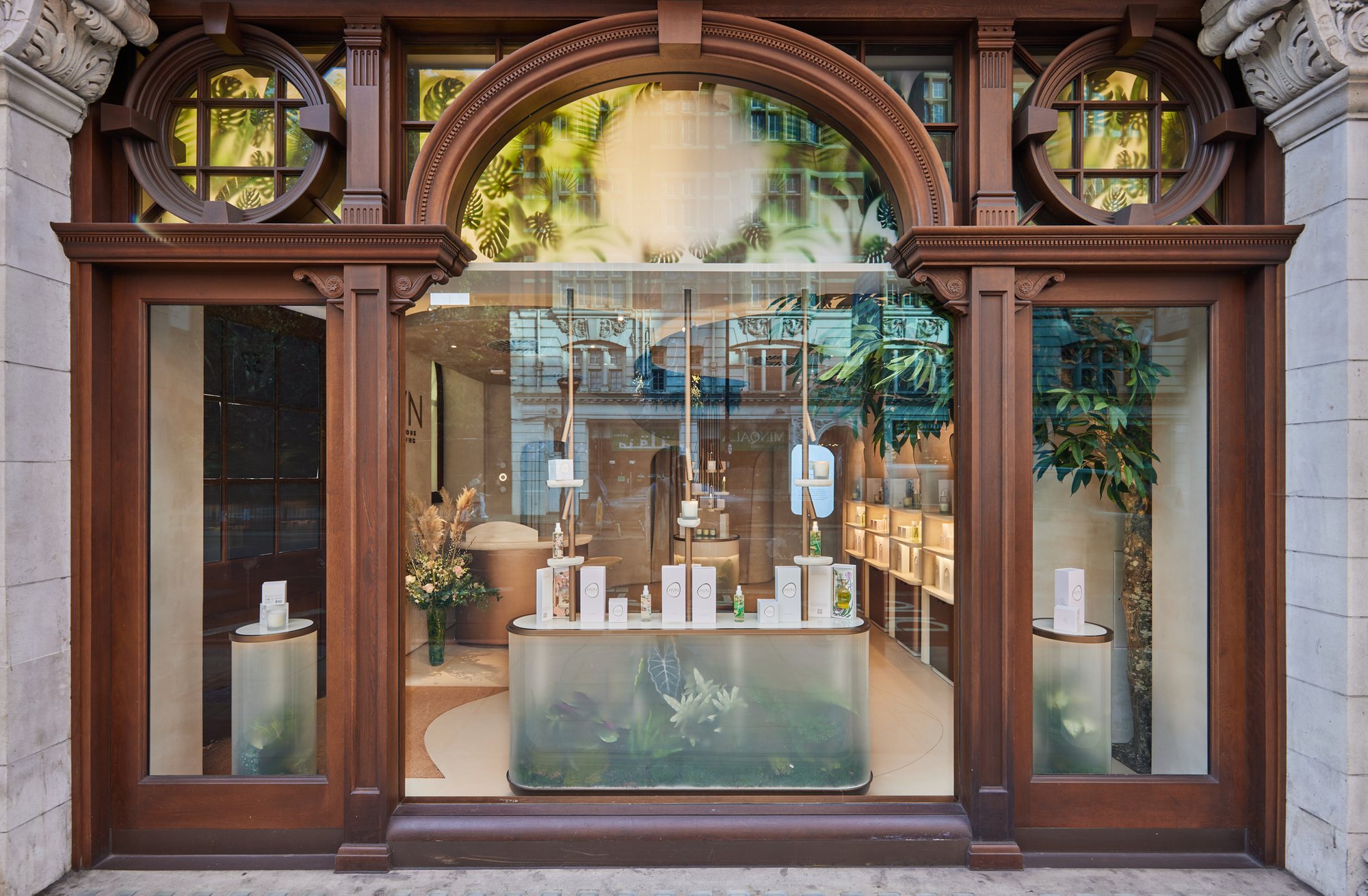 HVN Knightsbridge shopfront by SheridanCX, Edwardian mahogany frontage with a planted terrarium plinth and product line-up in the window
