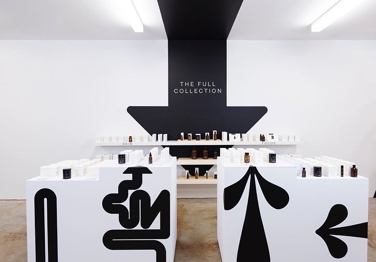 The Nue Co full collection wall with black arrow graphic, SoHo New York, by SheridanCX