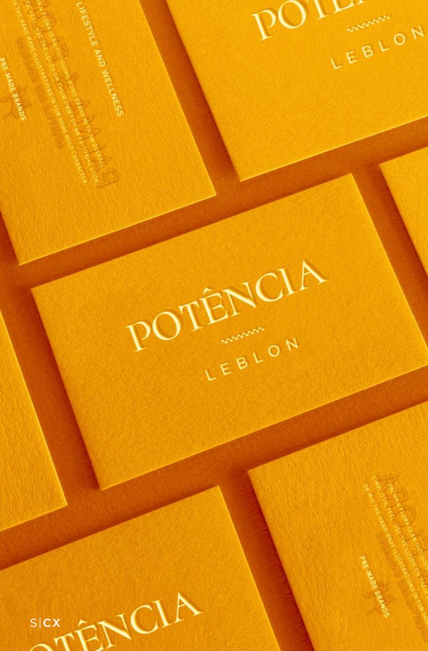 Embossed marigold business cards with the Potência Leblon serif mark