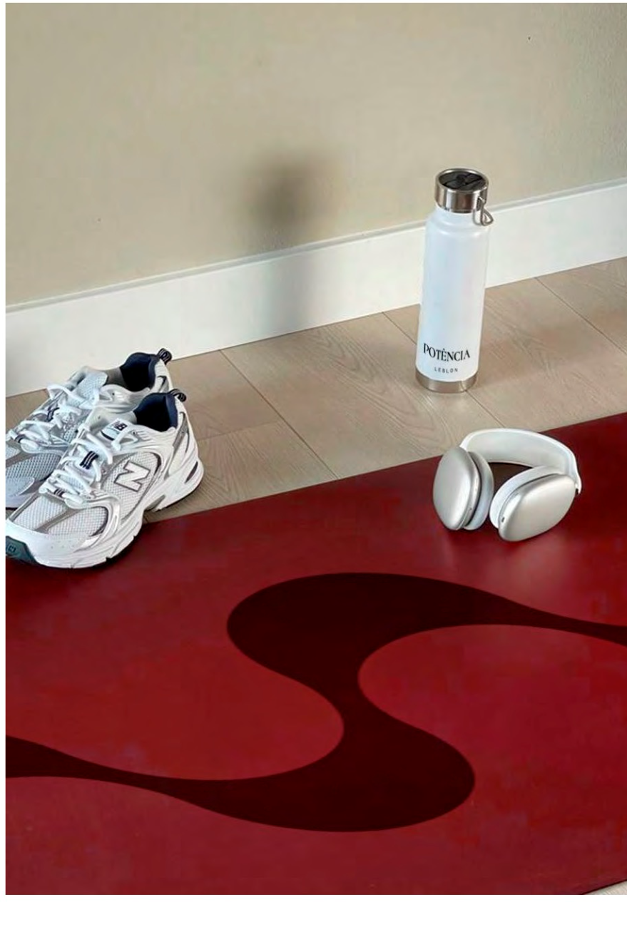 Branded water bottle, trainers and headphones on a red studio mat
